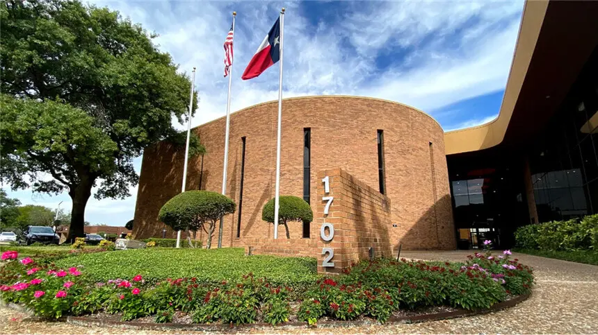 Building exterior with address 1702 and flags